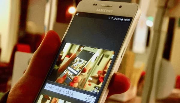 Mujer sostiene en su mano un smartphone de Samsung. Con pantalla encendida. ¿Qué es la calidad de servicio QoS?